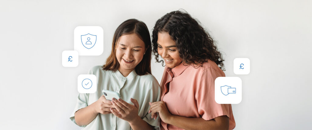 Two girls looking at a phone with banking symbols surrounding them